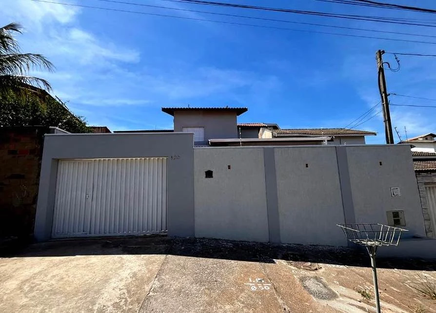 Fachada da casa vista da rua com portão e muro